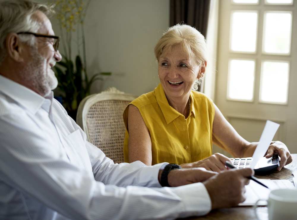 A senior couple reviews 401(k) retirement savings paperwork.